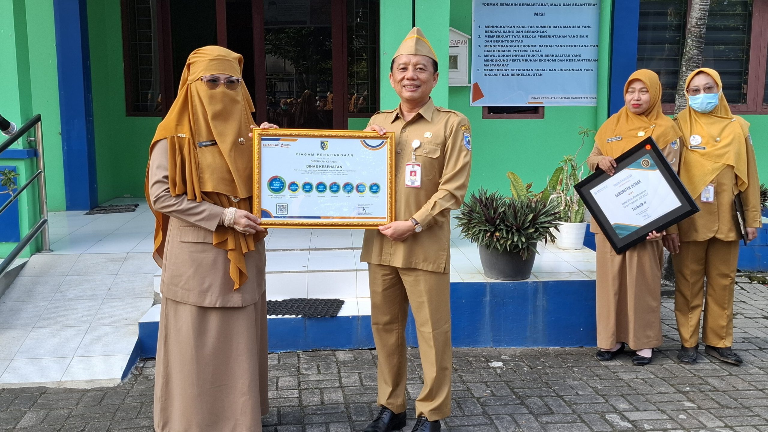 Dinkesda_Demak – Seni98n, 16 Juni 2025 menjadi momen istimewa bagi Dinas Kesehatan Daerah Kabupaten Demak. Dalam apel pagi yang dipimpin langsung oleh Kepala Dinas Kesehatan Daerah, dr. Ali Maimun, M.Kes., Dinkesda Demak menerimakan dua penghargaan prestisius sebagai bentuk apresiasi atas dedikasi dan kinerjanya. Penghargaan pertama diterima untuk kategori Kepatuhan Pembayaran Iuran Program JKN 2024 yang diberikan oleh BPJS Kesehatan, dengan predikat peringkat terbaik II Tingkat Provinsi Jawa Tengah. Piagam dan piala penghargaan ini diserahkan kepada Bidang Sumber Daya Kesehatan (SDK) dan diterima langsung oleh Kepala Bidang SDK, dr. Haerudin. Penghargaan kedua adalah apresiasi atas keikutsertaan dalam Survei Budaya Kerja ASN Ber-AKHLAK Perangkat Daerah Kabupaten Demak tahun 2023. Survei ini diikuti oleh 153 responden dari internal Dinas Kesehatan, dengan hasil yang membanggakan, yakni kategori "SEHAT", menandakan budaya kerja yang positif dan produktif. Piagam penghargaan ini diterimakan kepada Sekretariat Dinkesda, dan secara simbolis diserahkan kepada Sekretaris Dinas Daerah, Ibu Nani Amrin, S.KM., M.Kes. Kegiatan penyerahan berlangsung dengan khidmat di halaman kantor Dinkesda, disaksikan oleh seluruh pimpinan dan karyawan/karyawati. Dalam sambutannya, dr. Ali Maimun menyampaikan rasa syukur dan bangga atas pencapaian tersebut. “Penghargaan ini bukan sekadar simbol, tetapi cerminan dari kerja keras, sinergi, dan integritas seluruh jajaran. Semoga menjadi motivasi untuk terus memberikan pelayanan terbaik kepada masyarakat dan membangun budaya kerja ASN yang unggul,” ujar beliau. Pencapaian ini menjadi bukti bahwa Dinas Kesehatan Kabupaten Demak terus berkomitmen dalam meningkatkan mutu pelayanan kesehatan serta menanamkan nilai-nilai AKHLAK sebagai budaya kerja ASN.Pungkasnya (Kesmas_Promkes PM)